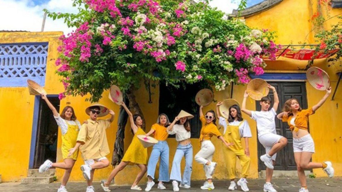 Tranh vẽ một góc phố yên bình tại Hội An với bức tường vàng, cửa sổ xanh và giàn hoa giấy thơ mộng