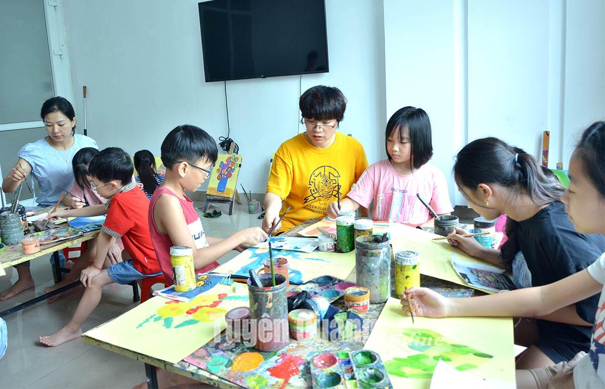 Các em thiếu nhi đang say sưa vẽ tranh chủ đề em yêu Hà Nội trong một lớp học mỹ thuật