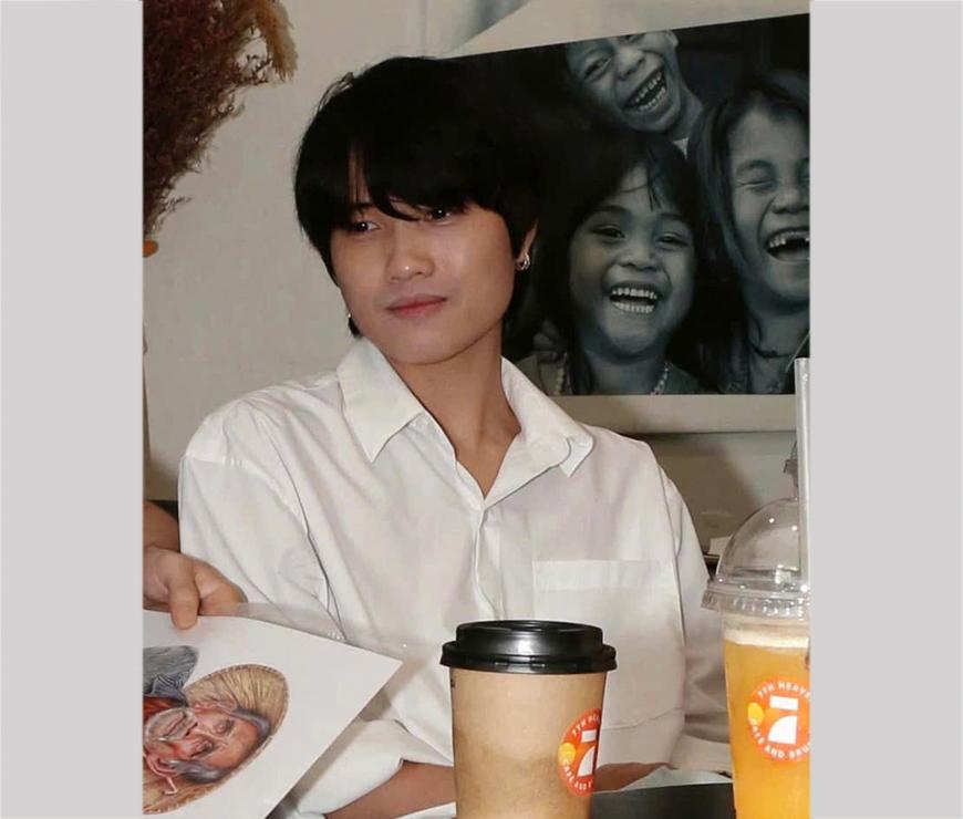 Hình ảnh một họa sĩ đang tập trung cao độ vẽ tranh bằng bút bi một tác phẩm phức tạp