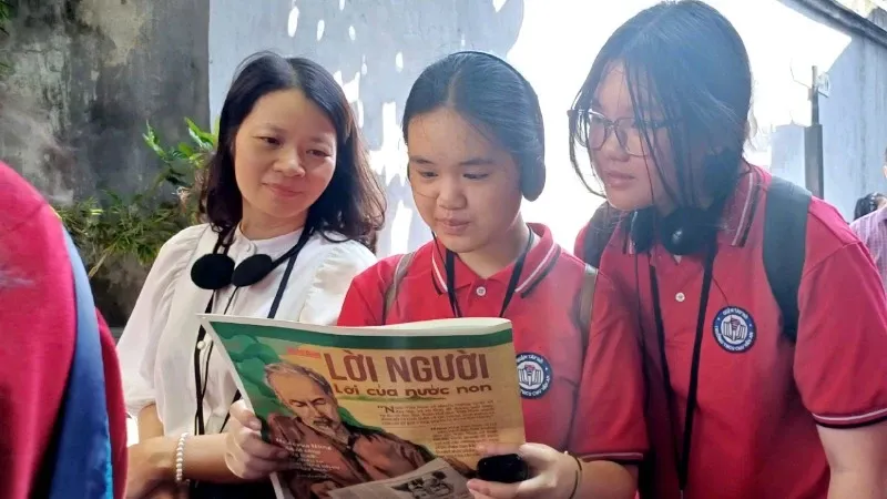 Tranh vẽ Bác Hồ đang ngồi đọc báo Nhân Dân thể hiện sự gần gũi