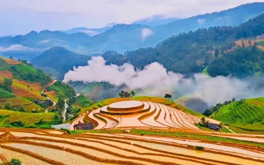 Bức tranh phong cảnh ruộng bậc thang mùa nước đổ với những thửa ruộng lấp lánh phản chiếu bầu trời