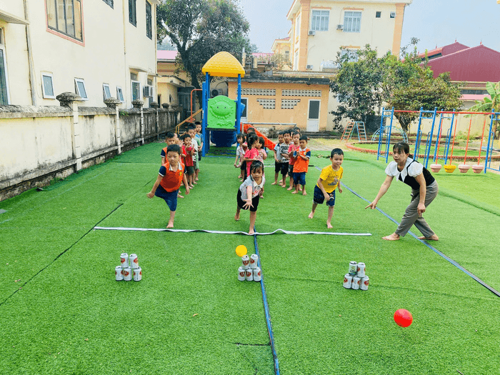 Bức tranh vẽ cận cảnh nhóm trẻ em đang chơi trò bịt mắt bắt dê với biểu cảm vui nhộn và thích thú