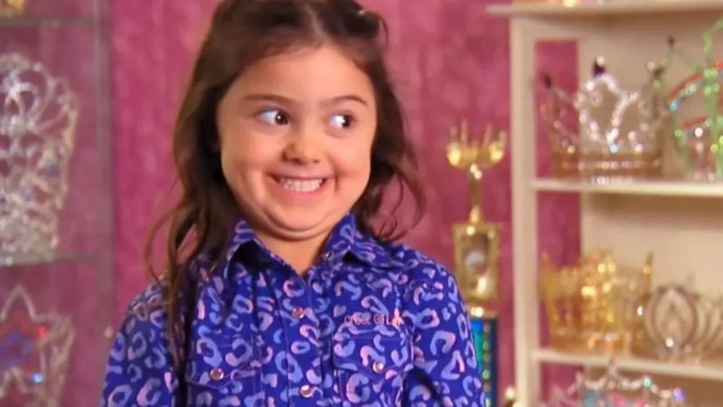 Ảnh chụp một người đang cố gắng mang vác nhiều thứ cùng lúc và trông rất chật vật