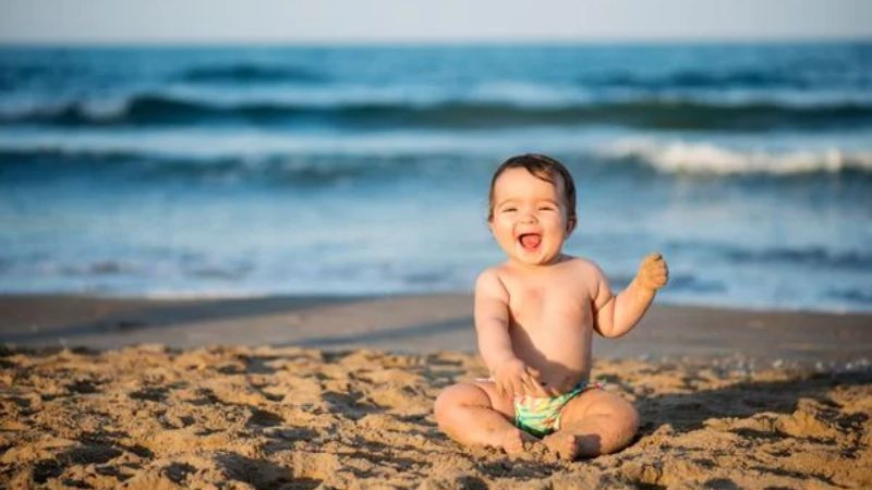 Ảnh em bé cute ngồi bên cửa sổ đón nắng