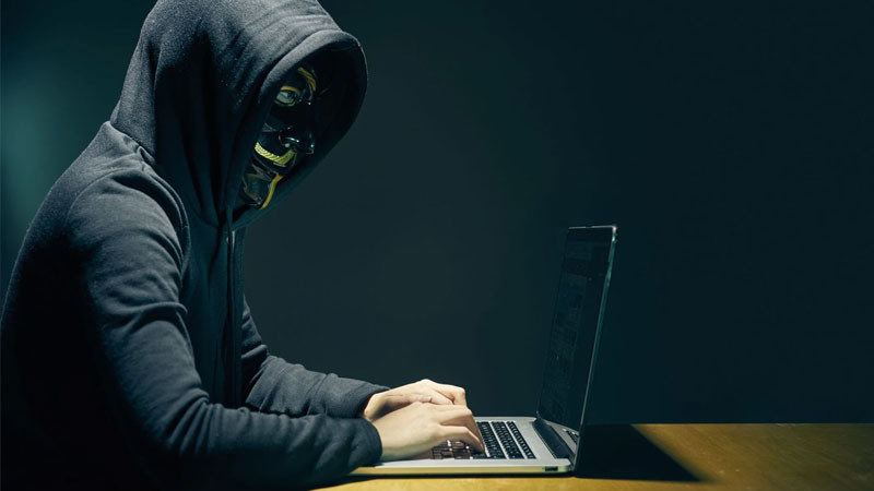 Ảnh hacker trầm tư trong phòng tối, chỉ có ánh sáng màn hình