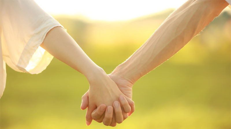 Ảnh nắm tay trên nền màu nâu đất, tạo cảm giác gần gũi