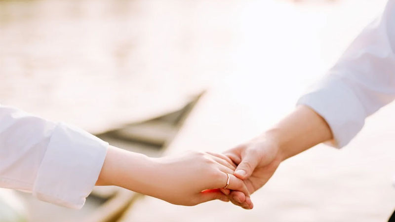 Ảnh nắm tay với bối cảnh hoa lá tươi tắn, phù hợp làm ảnh bìa