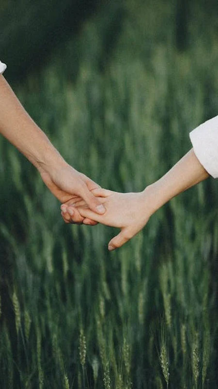 Ảnh nắm tay với bối cảnh nền màu hồng pastel dễ thương