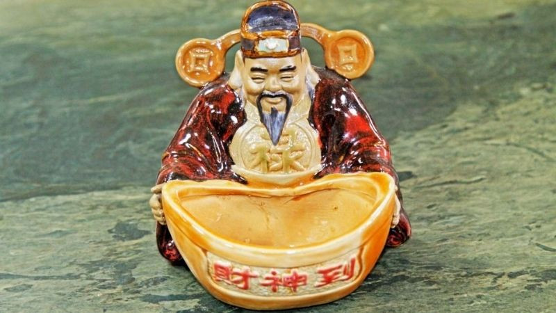 Ảnh nền Thần Tài tay cầm quạt và tiền vàng