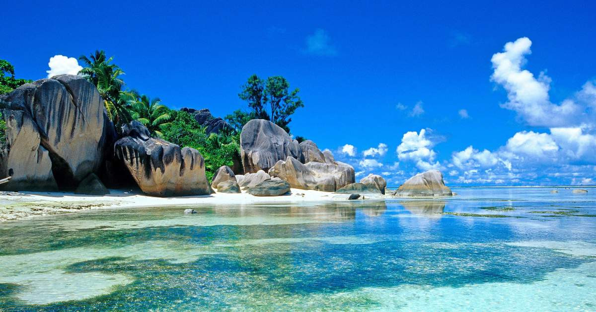 Bãi biển xanh ngắt với những tảng đá lớn trên bờ làm hình nền