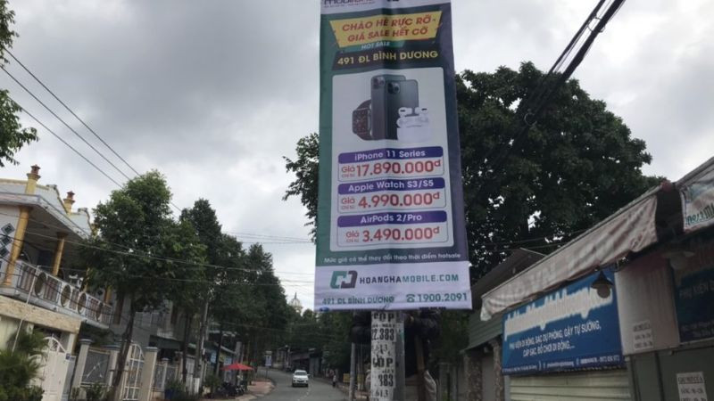 Banner quảng cáo ngoài trời treo trên đường phố thu hút người đi đường.