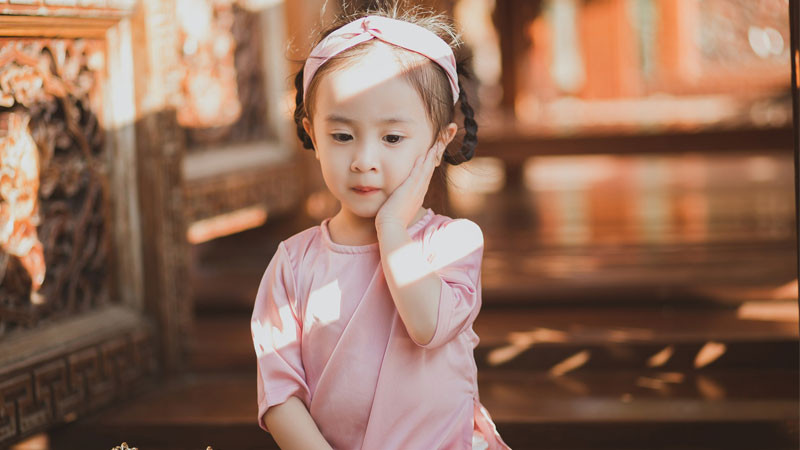 Bé gái châu Á cười với răng sún