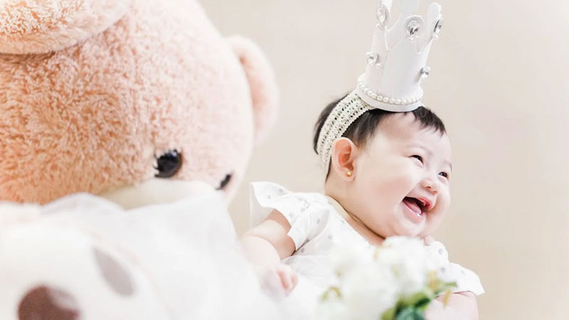 Bé gái đáng yêu đang ngồi trên bãi cỏ