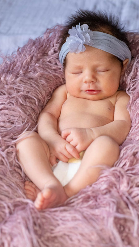 Bé gái sơ sinh ngủ co ro trong chăn