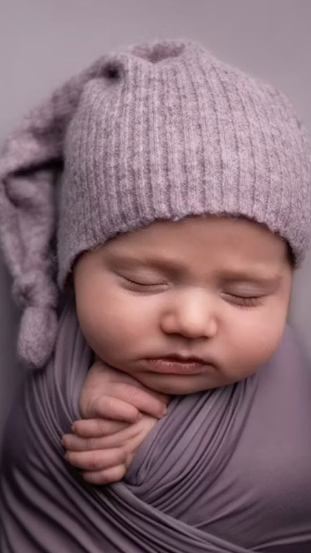 Bé gái sơ sinh ngủ trên nền lông mềm