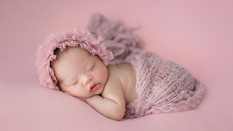 Bé gái sơ sinh ngủ trên tay mẹ