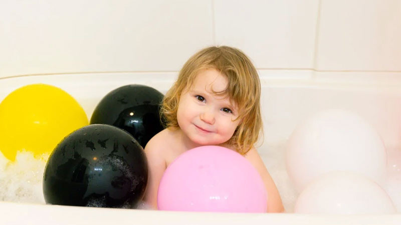 Bé gái sơ sinh ngủ với bàn tay nhỏ nắm lấy ngón tay người lớn