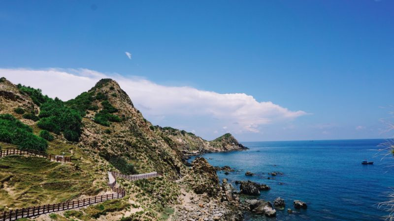 Bờ biển đá gập ghềnh với núi non phía sau, ảnh biển đẹp hoang sơ