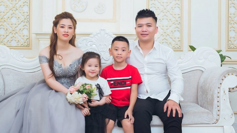 Bố cõng con trai, mẹ bế con gái, cả nhà đang đi bộ trên con đường