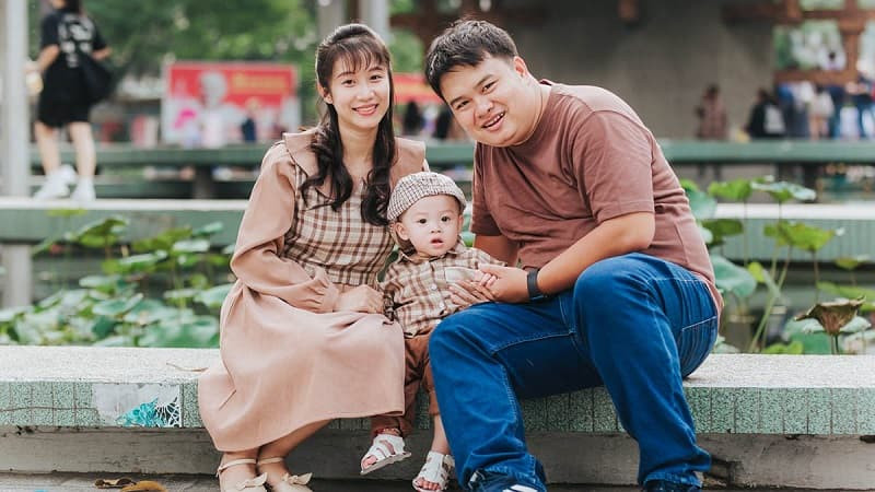 Bố mẹ hôn lên má con trai, bé cười rạng rỡ, khung cảnh hạnh phúc