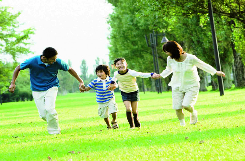 Bố mẹ và các con vui vẻ chơi đùa trên bãi cỏ