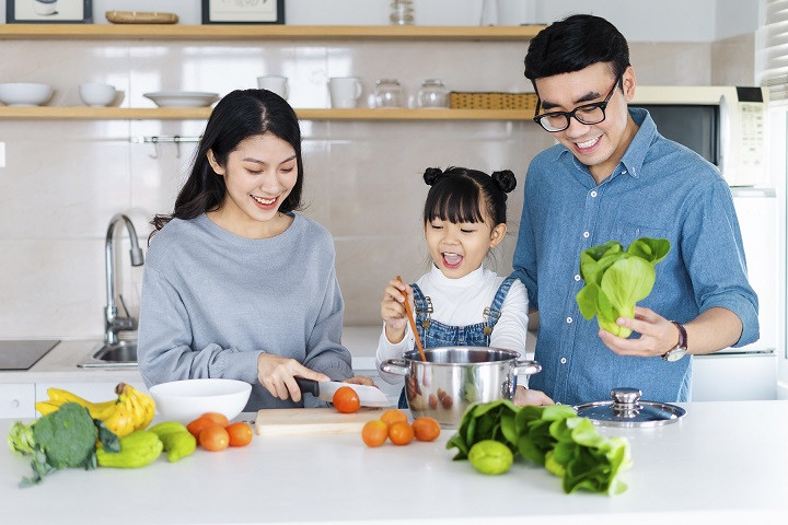 Bố mẹ và con cùng nhau chuẩn bị bữa ăn gia đình