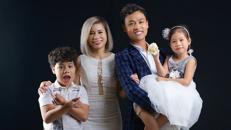 Bố mẹ và hai con gái mặc váy cùng màu, chụp ảnh tại studio