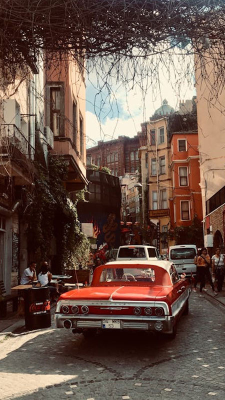 Bức ảnh ảnh đường phố mang phong cách cổ điển thập niên 80 90 với xe hơi cũ.