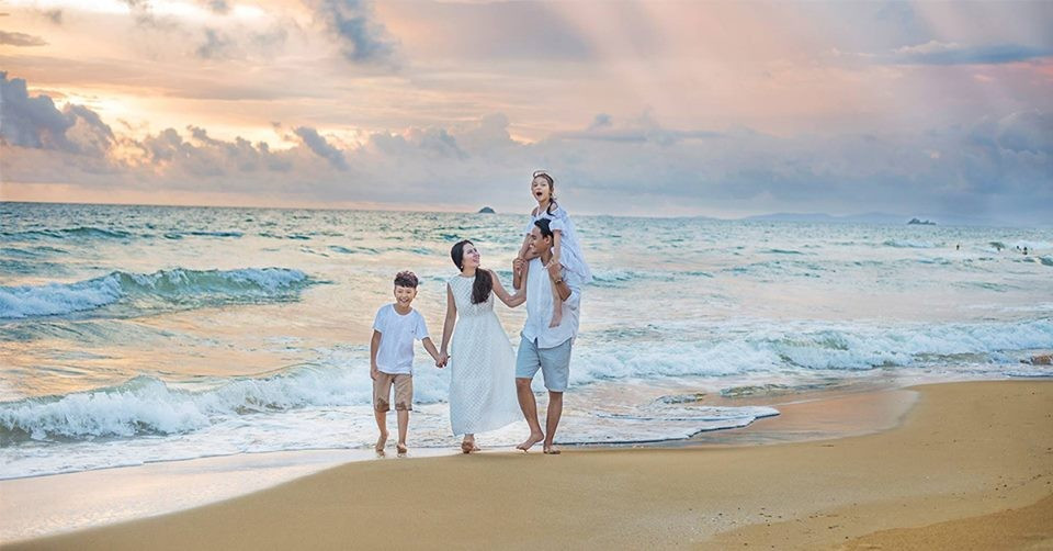 Cả gia đình 4 người dạo bước trên bãi biển đầy nắng