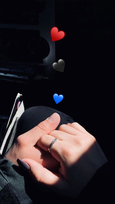 Cận cảnh bàn tay nữ đặt trên bàn tay nam, bối cảnh đơn giản