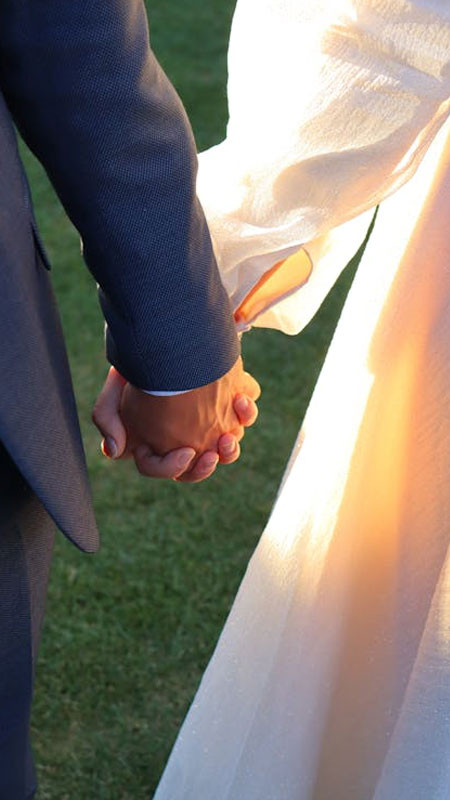 Cận cảnh hai bàn tay đan vào nhau, nhẫn cưới thể hiện tình trạng hôn nhân