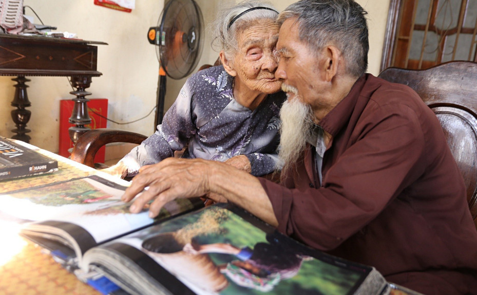Cặp đôi cao tuổi cùng nhau xem lại những bức ảnh kỷ niệm cũ