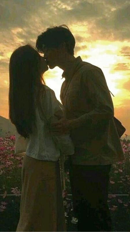 Cặp đôi trao nhau nụ hôn lãng mạn dưới ánh hoàng hôn