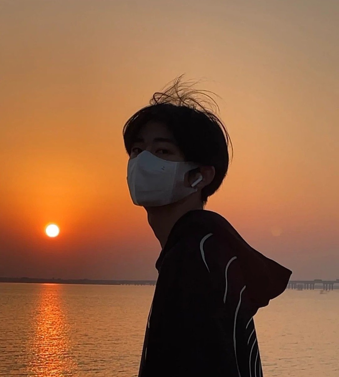 Chàng trai che mặt tạo dáng chất lừ trên phố lúc hoàng hôn