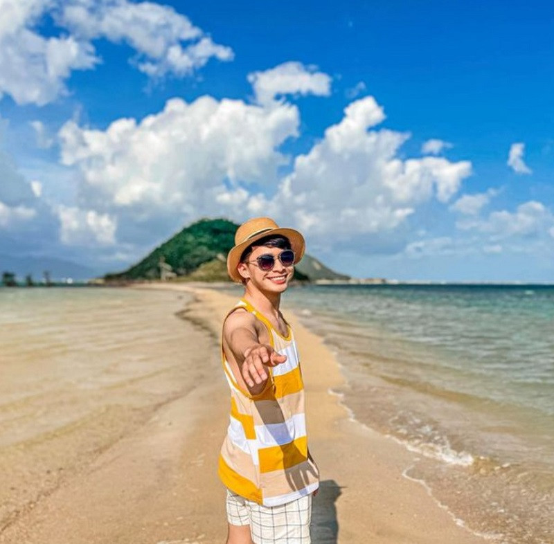 Chàng trai cười thân thiện trên bãi biển