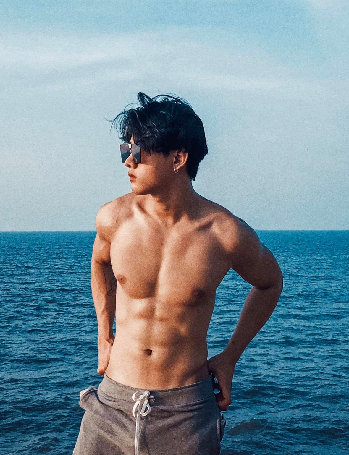 Chàng trai đeo kính râm trên biển