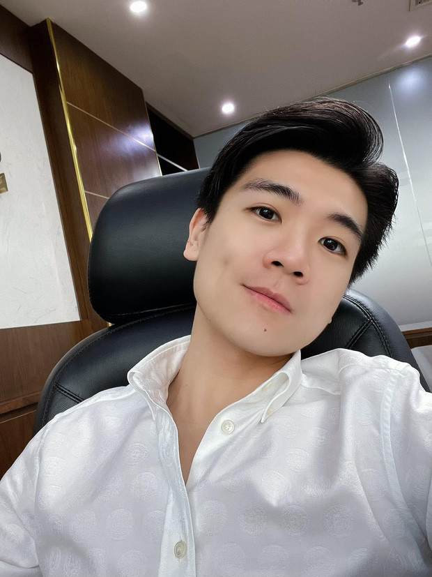 Chàng trai với má lúm đồng tiền mỉm cười khi mặc áo sơ mi trắng