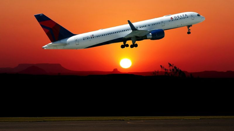 Chiếc máy bay đang bay lên cao, thân hình in bóng lên nền trời hoàng hôn đầy màu sắc