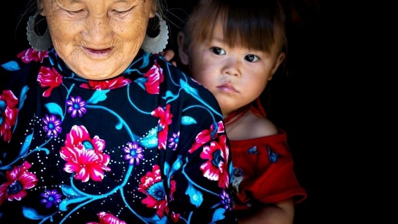 Cô bé ngại ngùng nấp sau lưng bà