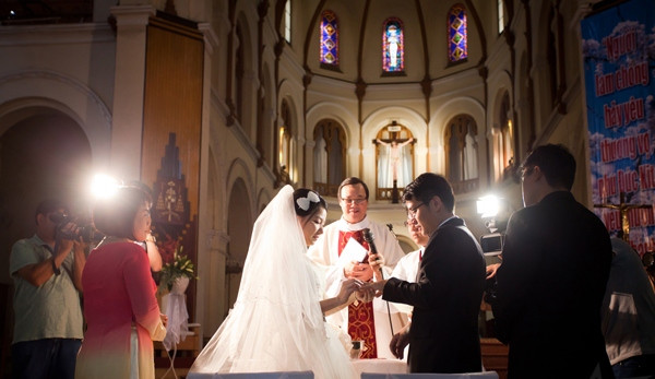 Cô dâu chú rể trao nhẫn cưới tại nhà thờ trong nghi thức hôn phối