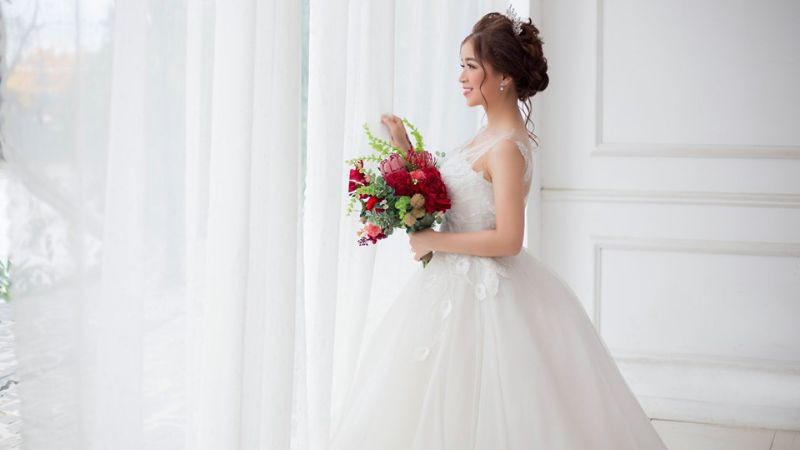 Cô dâu dịu dàng bên khung cửa sổ tràn ngập ánh sáng.