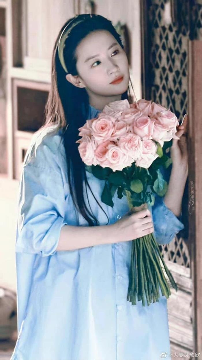 Cô gái cầm bó hoa hồng đỏ tươi thắm đầy quyến rũ