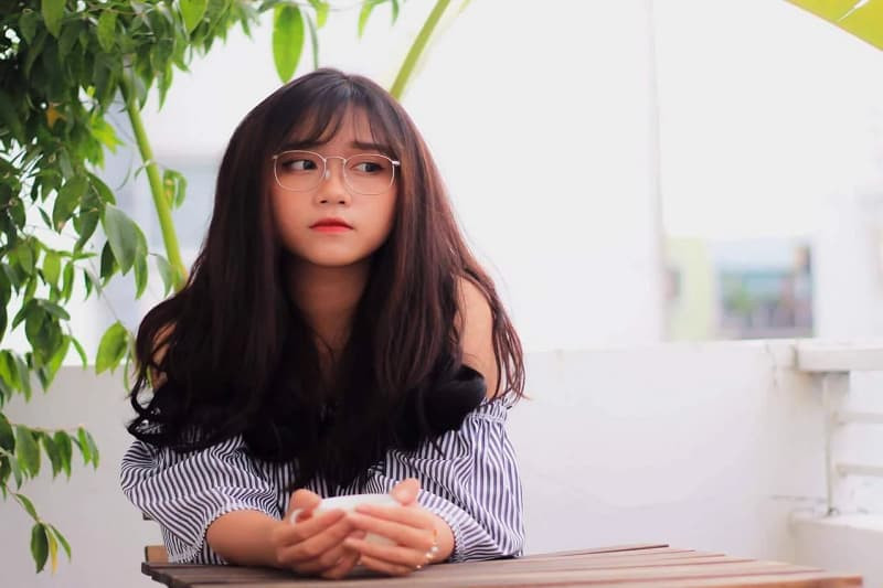 Cô gái đáng yêu đeo kính cầm sách