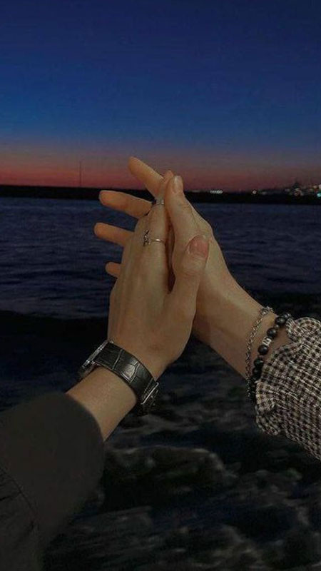 Đôi bàn tay đan vào nhau với bối cảnh biển xanh và bầu trời trong vắt