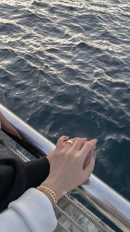 Đôi bàn tay nắm chặt khi bước đi trên bờ biển ngập nước