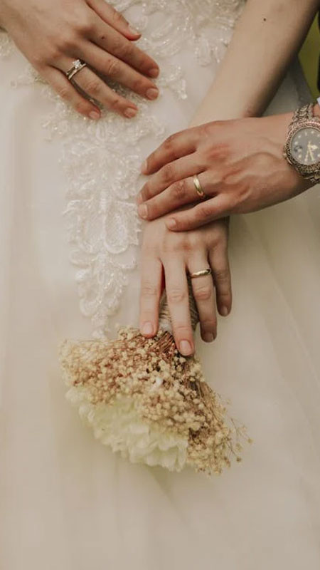 Đôi bàn tay nắm chặt thể hiện sự gắn bó với nhẫn cưới trên ngón áp út