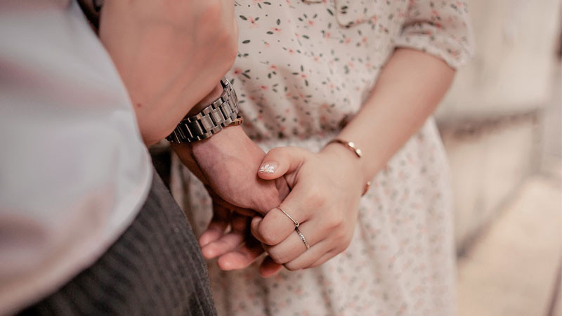 Đôi bàn tay nắm chặt trên nền màu vàng dịu nhẹ