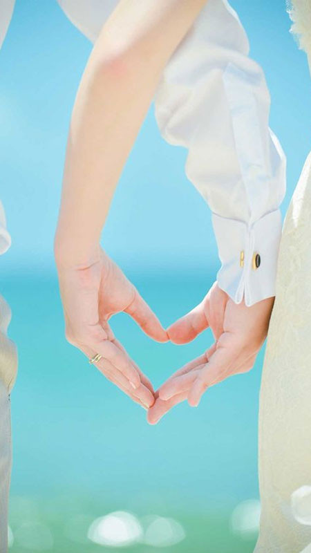 Đôi bàn tay nắm chặt trước cảnh hoàng hôn rực rỡ trên biển