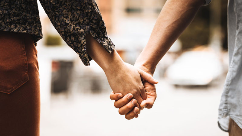 Đôi bàn tay nắm chặt với bối cảnh hoàng hôn trên nền trời và mặt nước