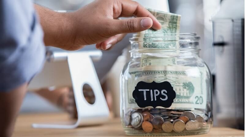 Đôi tay trao đổi tiền tip, minh họa ý nghĩa tips trong văn hóa dịch vụ